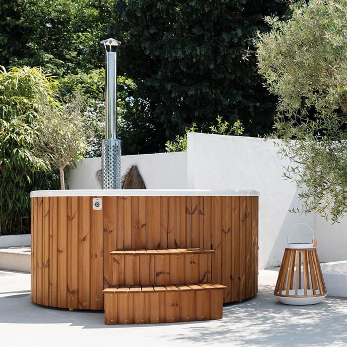 Foto van een houtgestookte hottub in een moderne witte tuin