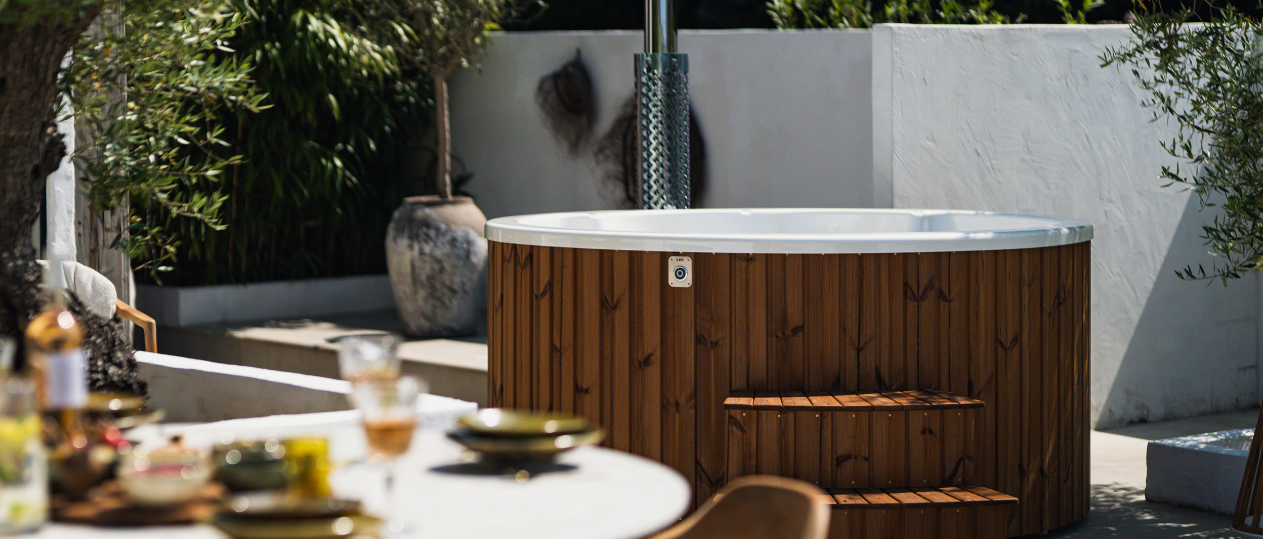 Afbeelding van een hottub in een grote tuin met tuintafel