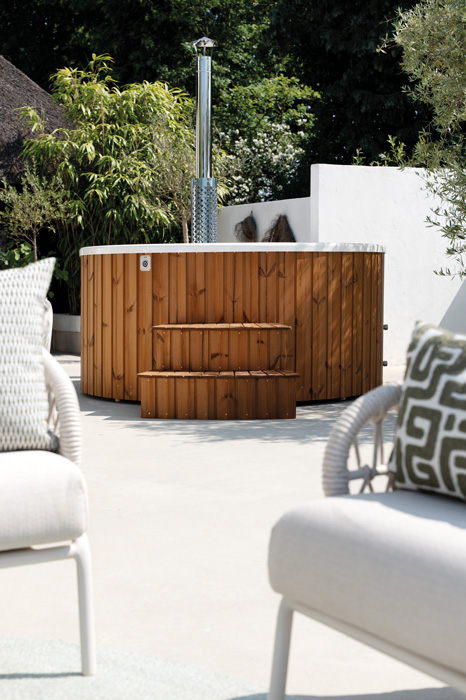 Hottub met witte tuinstoelen op de voorgrond