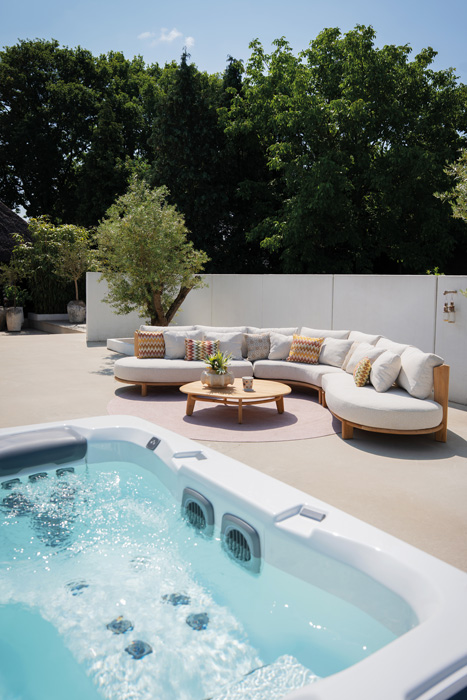 Spa in een luxe tuin met tuinmeubelen op de achtergrond